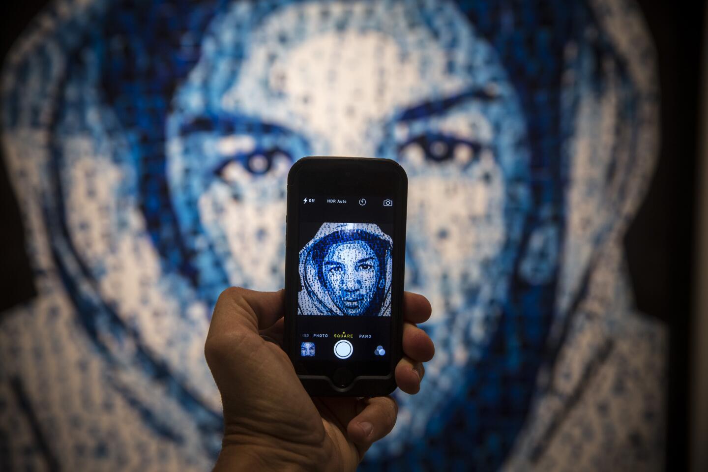 The face of Trayvon Martin, as rendered in "Trayvon Memorial," glows on a phone's screen. The artwork by Gerri Lawrence, collaborating with Raul Ocampo, is among more than 220 works by an estimated 150 artists presented in "Manifest Justice," a pop-up exhibition in Los Angeles.