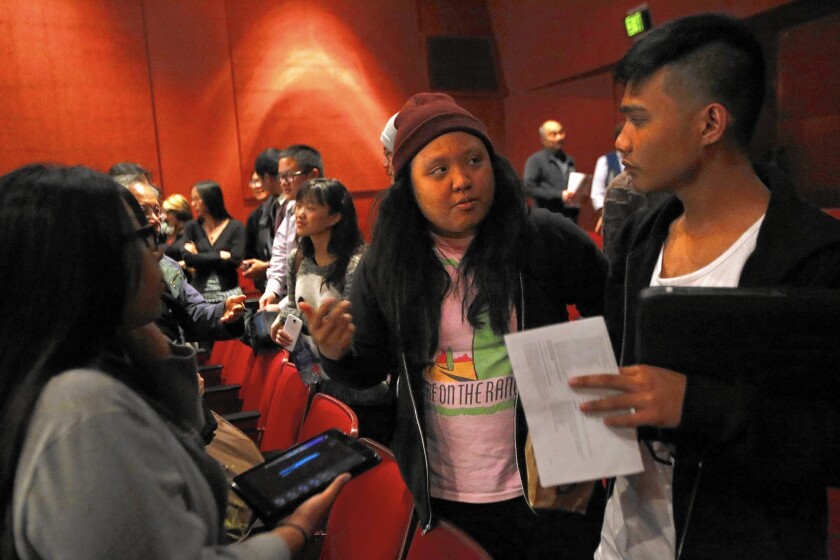 Cal State Northridge student Thea Fernandez, center, talks with Karl Pascasio at a public meeting about plans to limit enrollment.