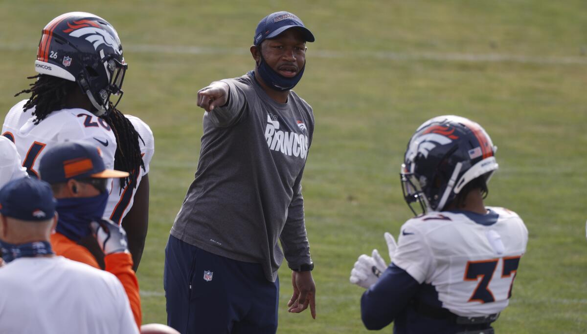 Denver Broncos defensive backs coach Renaldo Hill directs players in drills.