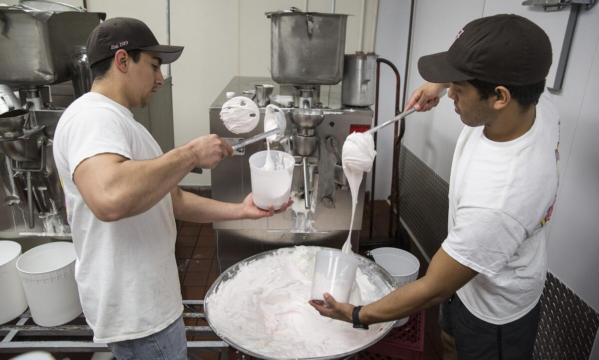 Fosselman's Ice Cream employees Moses Munoz, left, and Jacob Barrios package fresh cherry vanilla ice cream.