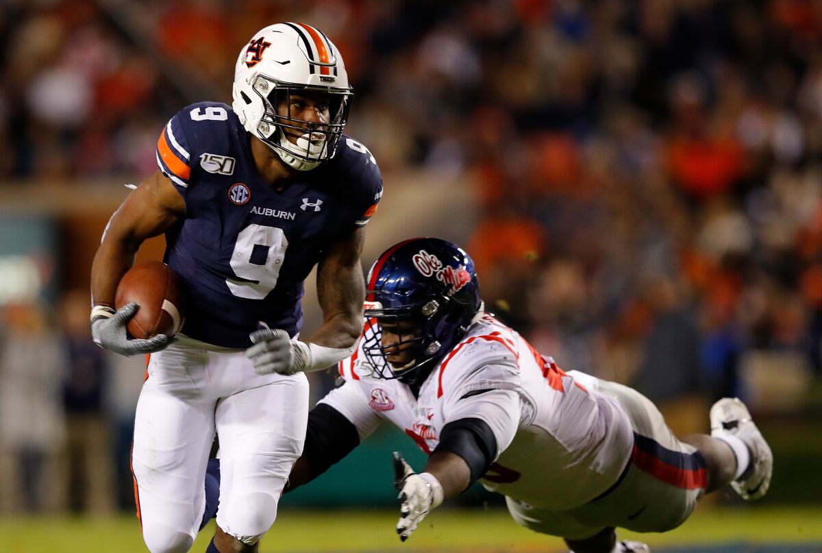 Auburn's Kam Martin (9) rushes past Mississippi's Josiah Coatney (40) in the first half on Saturday.