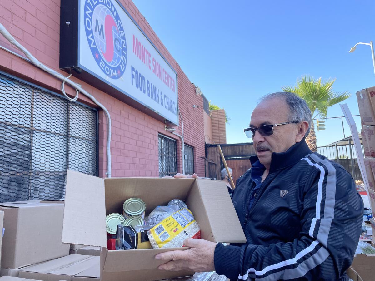 Mario Rivera, director de operaciones de Monte Sión Center, muestra una caja con alimentos enlatados.