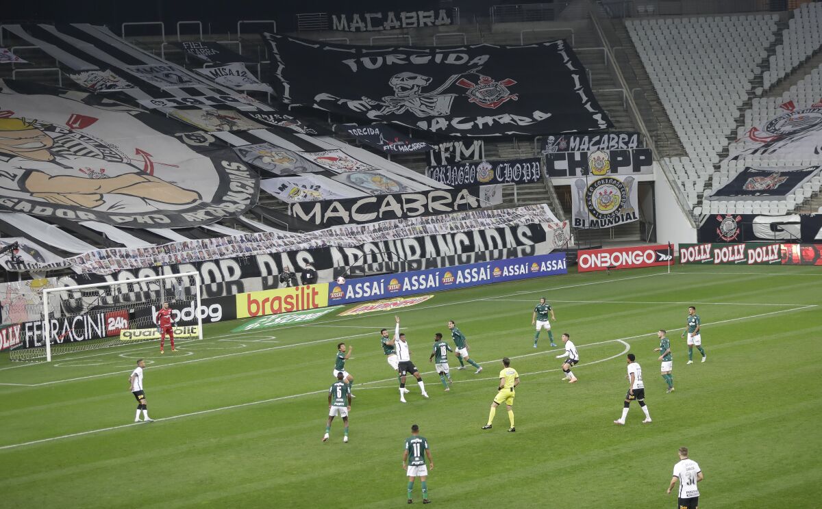 Players of Corinthians, in white, and Palmeiras play the Sao Paulo league first leg final soccer match at the Arena Corinthians stadium in Sao Paulo, Brazil, Wednesday, Aug. 5, 2020. The match is being played without spectators to curb the spread of COVID-19. (AP Photo/Andre Penner)