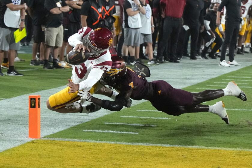 USC quarterback Caleb Williams stretches out to score a touchdown while getting shoved by ASU's Shamari Simmons 
