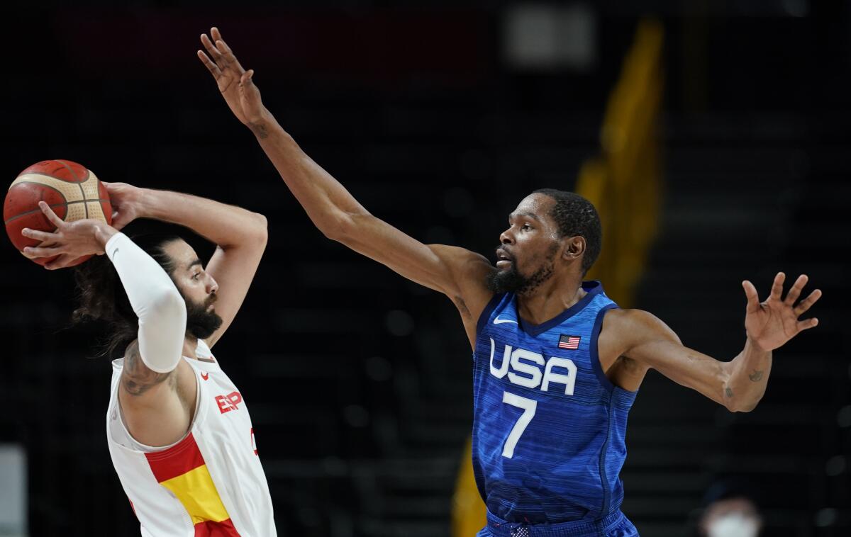 United States' Kevin Durant (7), right, tries to block Spain's Ricky Rubio (9), left, during men's basketball quarterfinal game at the 2020 Summer Olympics, Tuesday, Aug. 3, 2021, in Saitama, Japan. (AP Photo/Charlie Neibergall)