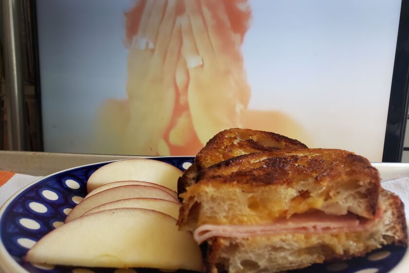 A grilled ham and cheese sandwich and apple slices while the 1988 disaster flick "Miracle Mile" plays on TV. (For a story about pairing disaster movies and food during the COVID-19 pandemic.)