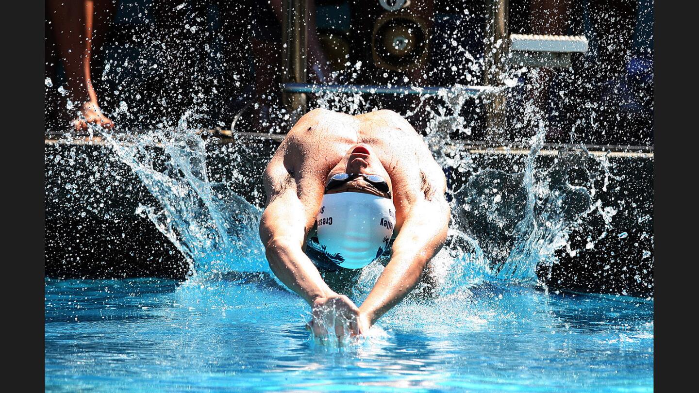 Crescenta Valley's Blake Williams launches at the start of the boys' 200 yard medley relay in the Pacific League swim finals at Burbank High School on Thursday, May 4, 2017.