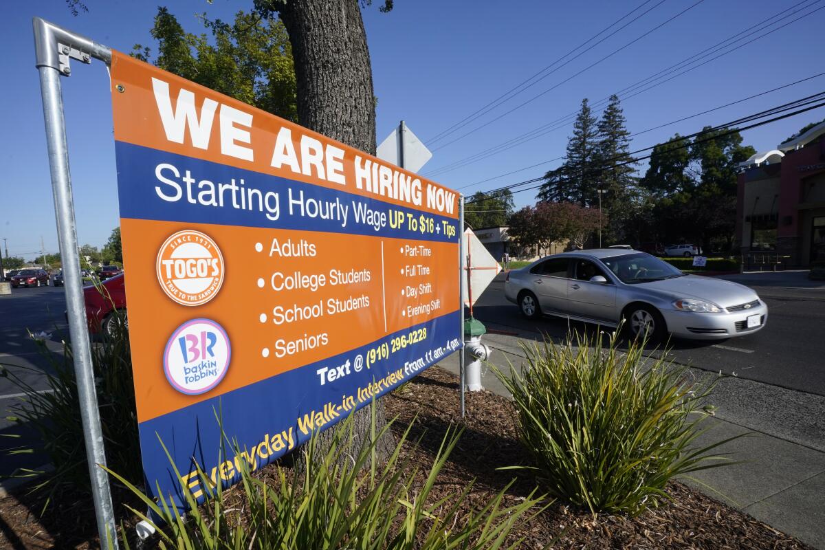 A banner by a road reads: "We are hiring now."