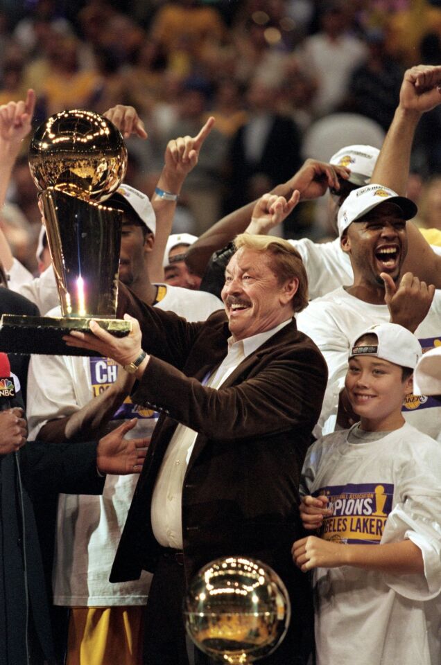 Jerry Buss holds aloft the NBA championship trophy after the Lakers defeated the Indiana Pacers for the 1999-2000 title, the franchise's first since the Showtime Era in the 1980s.