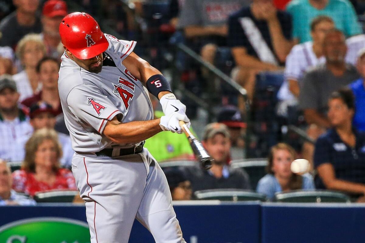 Albert Pujols hits a two-run RBI single in the eighth inning of the Angels' 4-3 loss to the Braves on Friday.