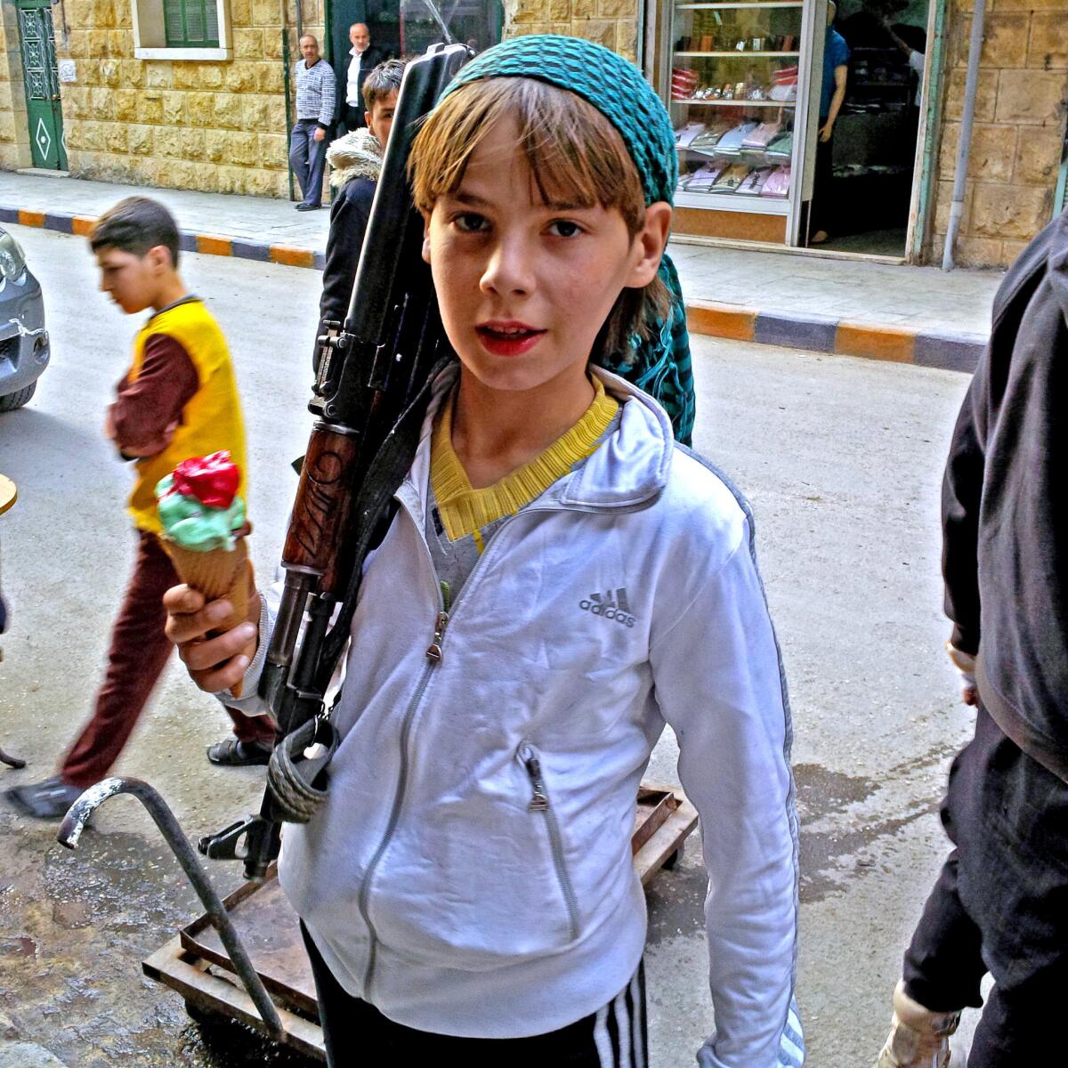 An armed boy in Aleppo, Syria, says he is a fighter with the Suqoor al Sham rebel group. He claimed to have been born in 1989, making him 24 or 25.