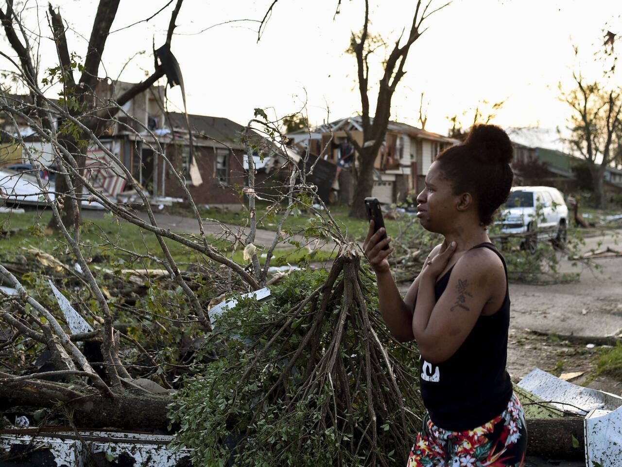 A resident of the West Brook neighborhood of Trotwood, Ohio, inspects damageon her street on Tuesday morning.