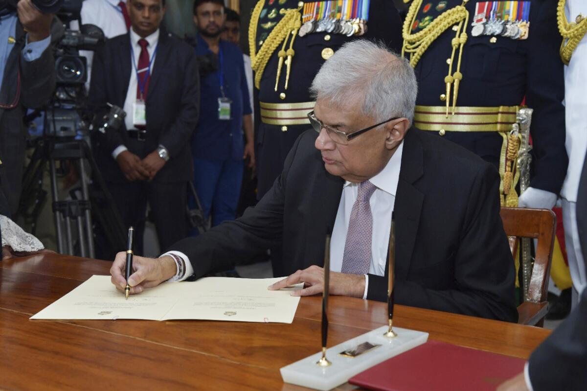 el presidente recién elegido Ranil Wickremesinghe firma un documento 