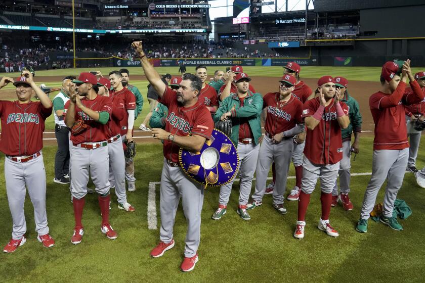 Mexico manager Benjamin Gil, middle, and others celebrate the team's 10-3 victory over Canada in a World Baseball Classic game in Phoenix, Wednesday, March 15, 2023. Mexico advanced to the quarterfinals. (AP Photo/Godofredo A. Vásquez)