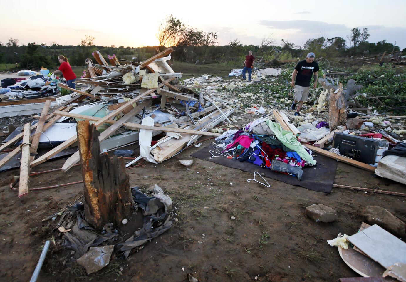 Friends and family of Lisa Buckner, not pictured, help to clean up after a tornado destroyed Buckner's home west of Wynnewood, Okla., in rural Gavin County, Monday, May 9, 2016.