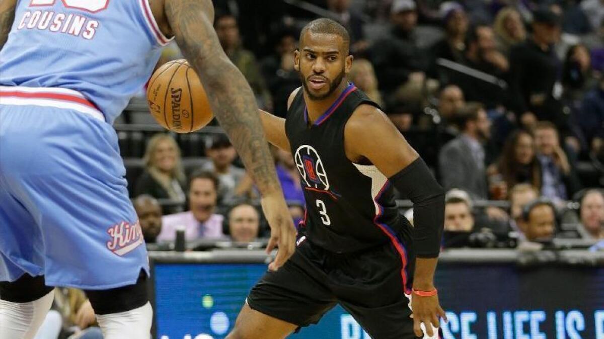 Clippers guard Chris Paul looks to pass while being defended by Kings big man DeMarcus Cousins during a game in Sacramento on Jan. 6.