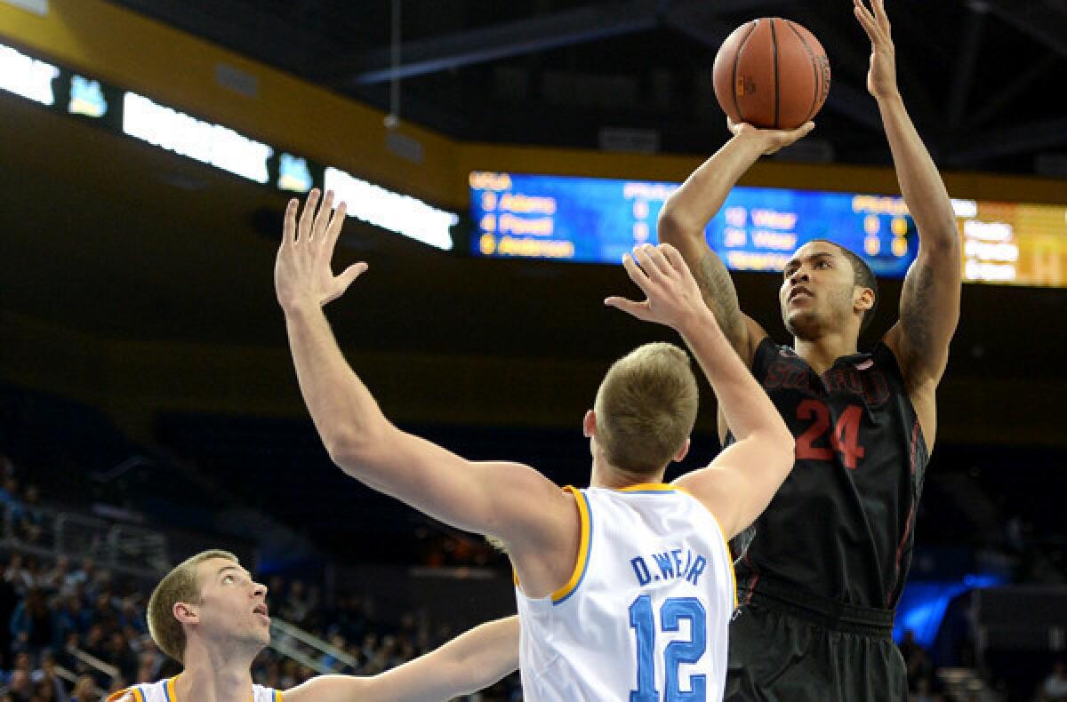 Stanford forward Josh Huestis elevates for a shot over UCLA forwards David Wear (12) and Travis Wear during their game earlier this season at Pauley Pavilion.