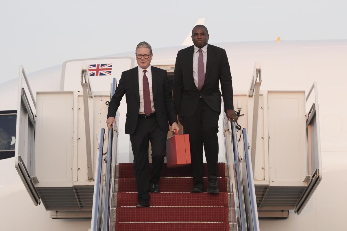 Britain's Prime Minister Keir Starmer, left, and Foreign Secretary David Lammy step from their aircraft.