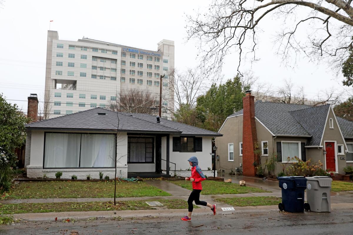 A jogger passes single family homes along the 4300 block of U St. in the Elmhurst neighborhood of Sacramento
