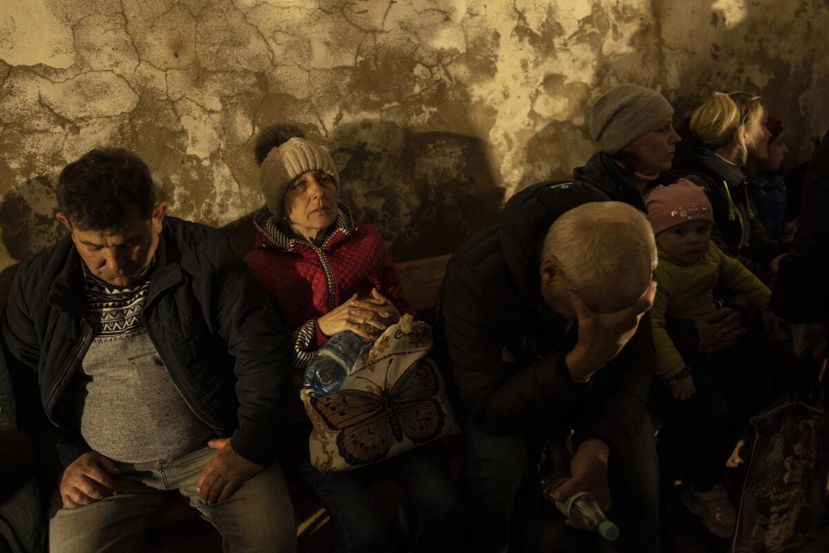 People hide in a basement of a church that is used as a bomb shelter.