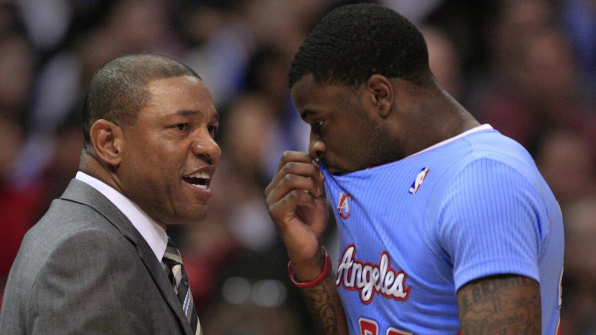 Clippers Coach Doc Rivers, left, speaks with guard Reggie Bullock during a game against the Chicago Bulls in November 2013.