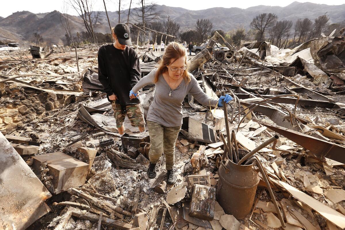 Michelle O'Wings with her husband's son Kodie Glover search the rubble of her Seminole Springs home after it was destroyed.