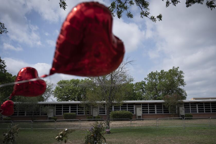 A heart shaped balloon flies decorating a memorial site outside Robb Elementary School in Uvalde, Texas, Monday, May 30, 2022. 19 children and two teachers were killed by an 18-year-old gunman at the school last week. (AP Photo/Wong Maye-E)