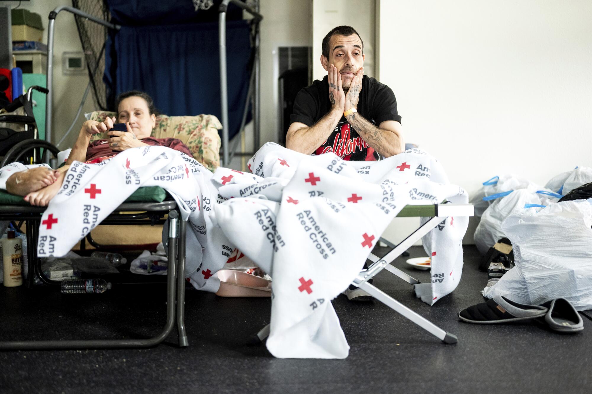 Chris Tierc and his mom, Melody Barnett, rest at a Red Cross shelter in Weed, Calif., on Monday.