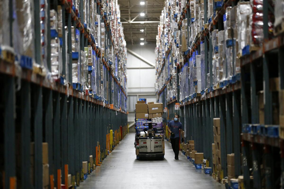 Associates fill orders for Ralphs and Food 4 Less grocery stores at the Ralphs Distribution Center in Riverside. 