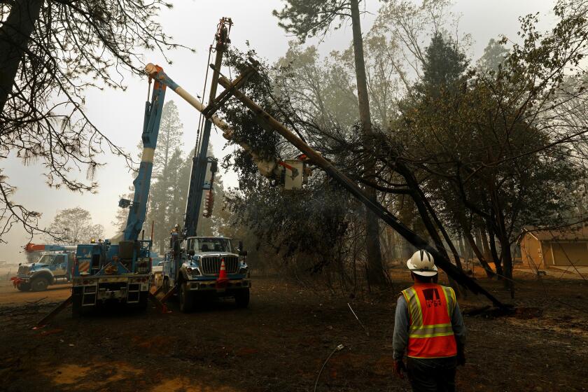 Carolyn Cole  Los Angeles Times PG&E CREWS clear a damaged power pole after the wildfire, which state investigators blamed on the utility’s equipment.