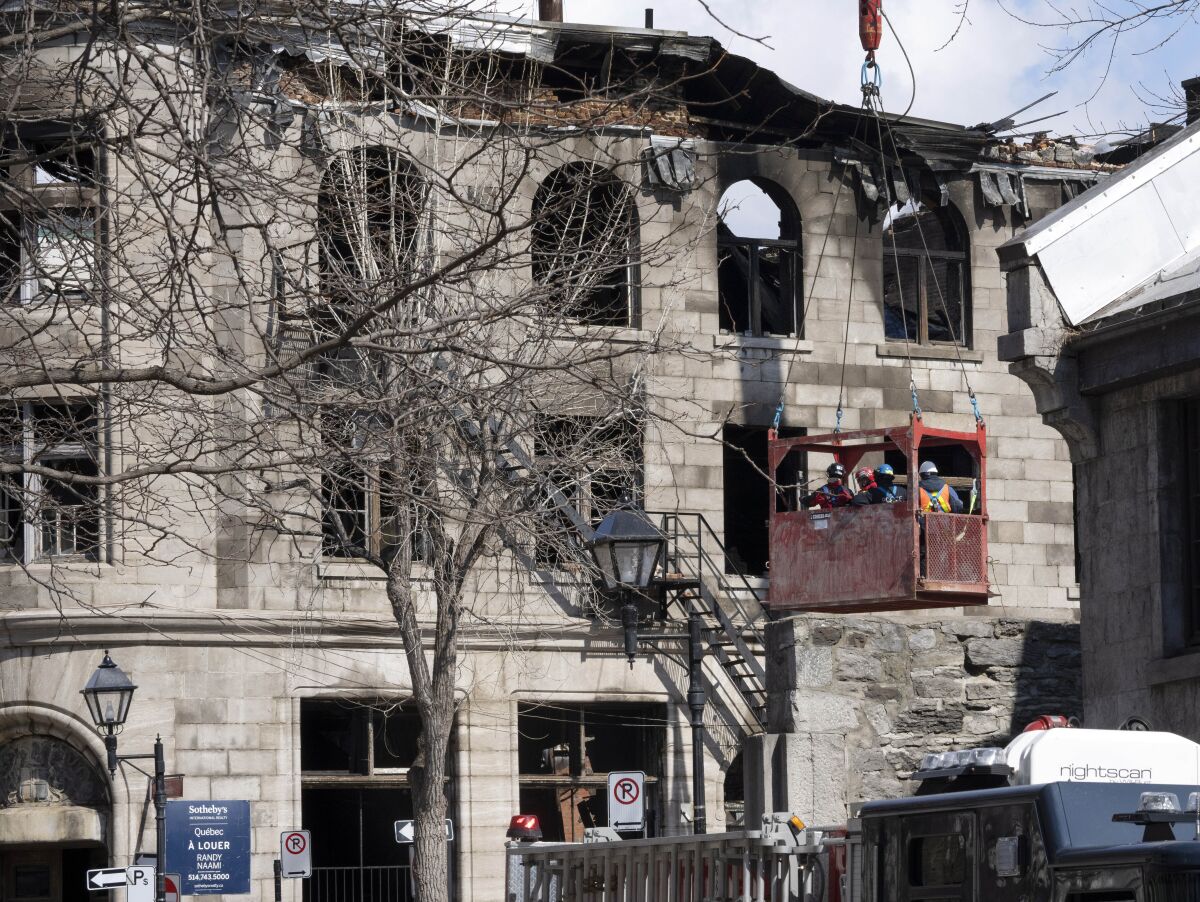 Firefighters continue the search for victims Monday, March 20, 2023 at the scene of last week's fire in Montreal