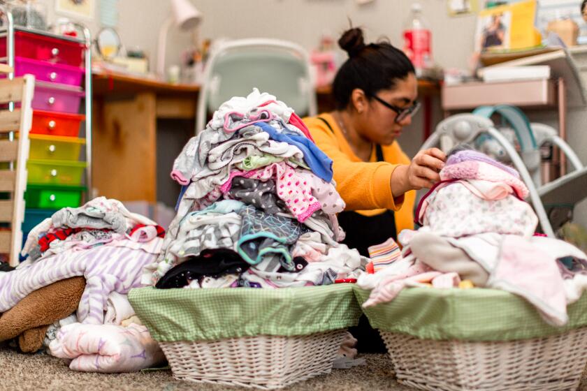 A woman tackle piles of laundry.
