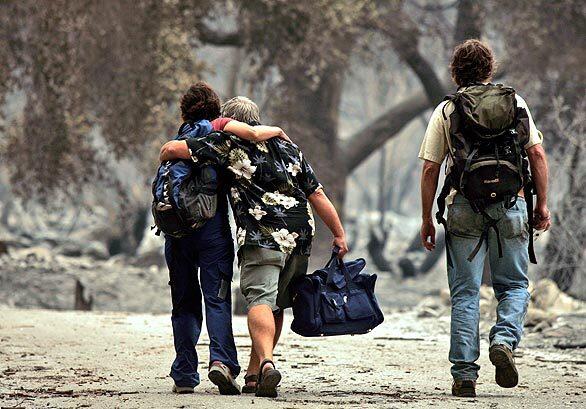 Tujunga neighbors support each other as they walk on La Paloma Canyon Road towards their homes in Vogel Flat.