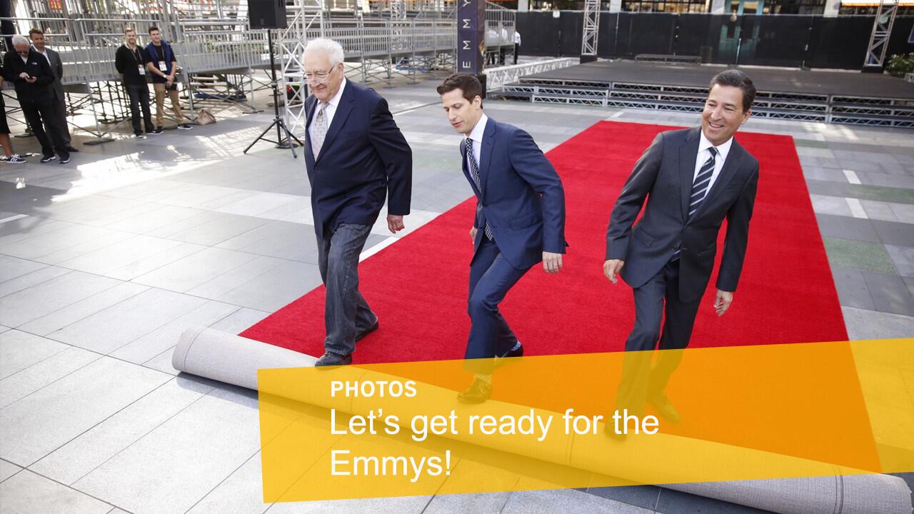 Andy Samberg, host of the 2015 Emmy Awards, center, rolls out the red carpet with executive producer Don Mischer, left, and Television Academy Chairman/CEO Bruce Rosenblum during a press preview three days before the show.