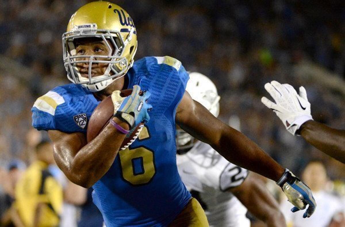 Bruins running back Jordon James scores against Nevada in the third quarter of the season-opening game at Rose Bowl.