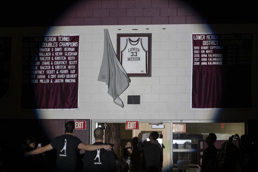 Kobe Bryant's Lower Merion jersey is unveiled in the Bryant Gymnasium during a ceremony at Lower Merion High School, Saturday, Feb. 1, 2020, in Ardmore, Pa. The school paid tribute to Bryant, his daughter and the seven other victims of a helicopter crash in California. (Charles Fox/The Philadelphia Inquirer via AP)