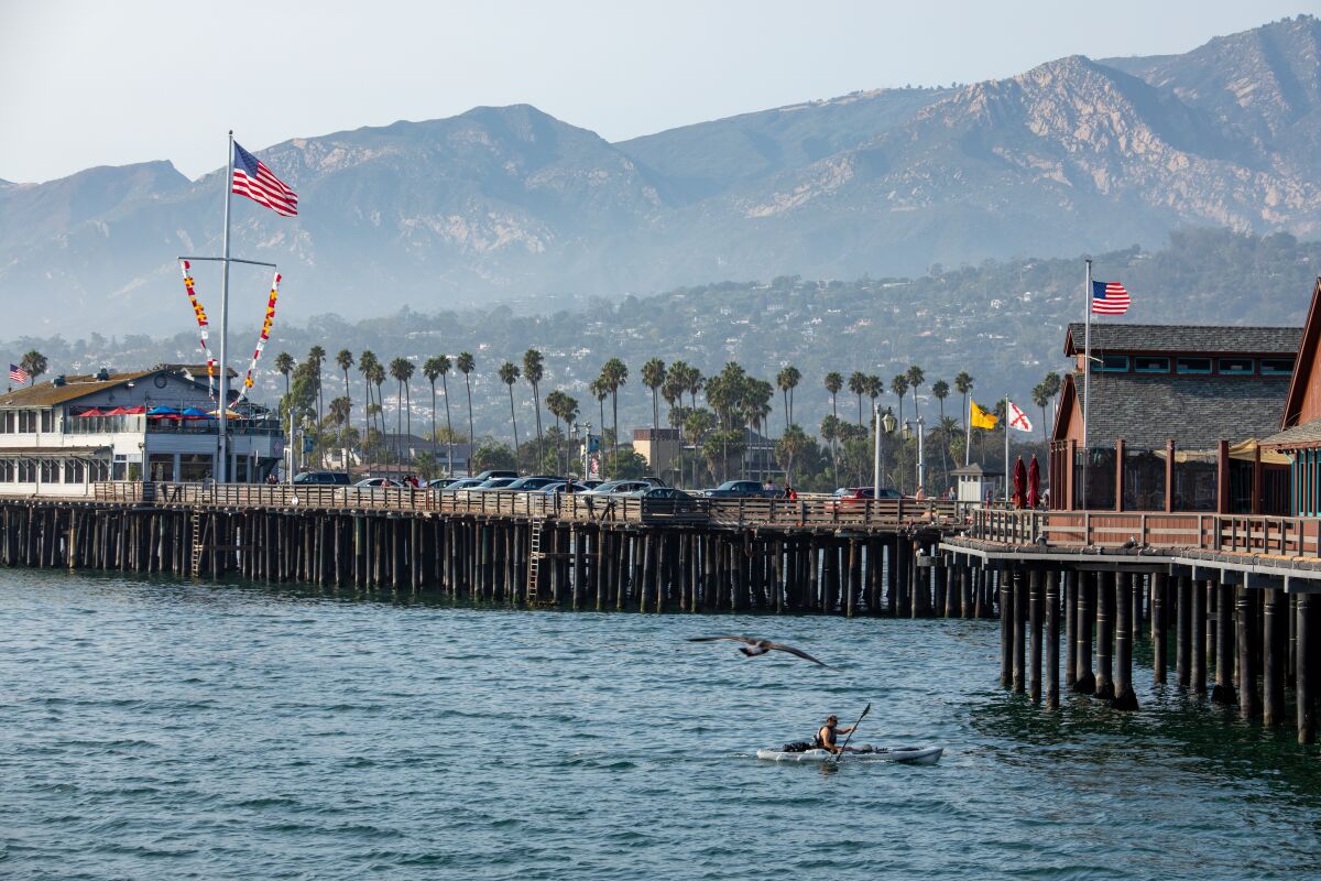 A kayaker rows by the Stearns Wharf in Santa Barbara in September. 