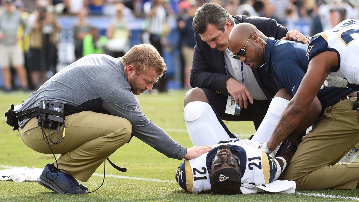 Rams coach Sean McVay comforts cornerback Kayvon Webster after he ruptured his Achilles' tendon during the first half of Sunday's game against Philadelphia.