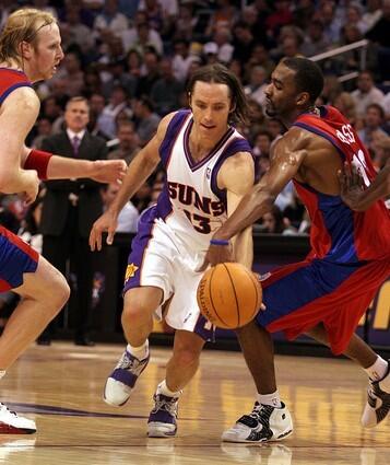 Phoenix Suns guard Steve Nash, center, dribbles between Los Angeles Clippers Chris Kaman, left, and Quentin Ross.