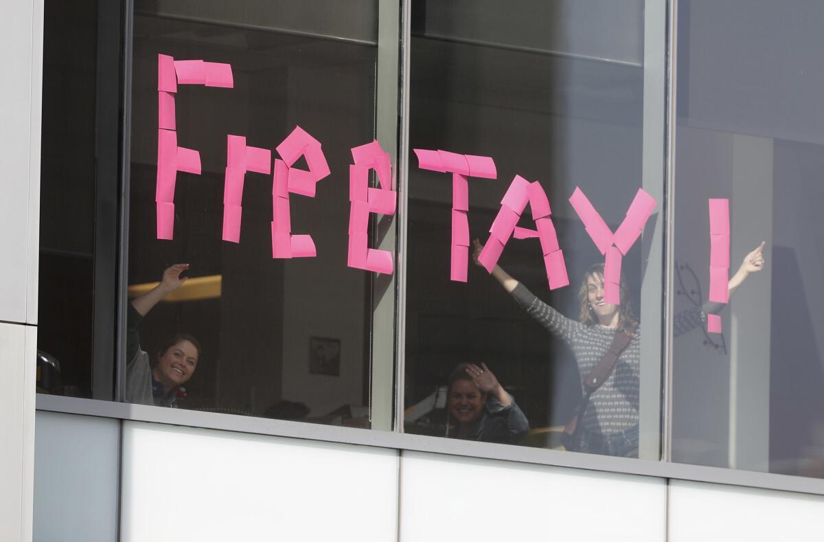 Denver workers put up signs Tuesday in an office building across the street from the federal courthouse where Taylor Swift and David Mueller are standing trial.