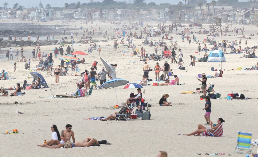 Beach-goers enjoy a warm day north of the Newport Beach pier in April.