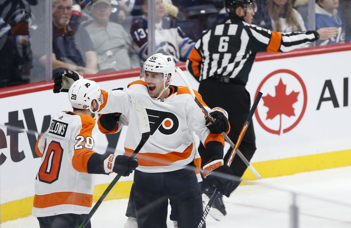 Philadelphia Flyers' Kieffer Bellows (20) and Rasmus Ristolainen (55) celebrate Bellows' goal against the Winnipeg Jets during the second period of an NHL hockey game, Saturday, Jan. 28, 2023 in Winnipeg, Manitoba. (John Woods/The Canadian Press via AP)