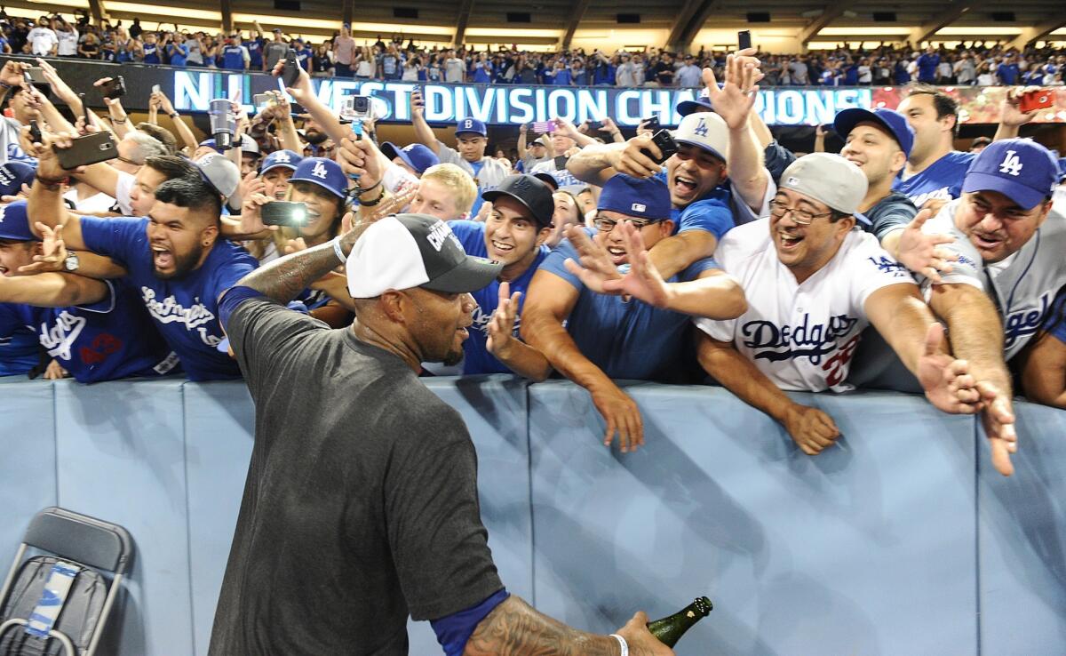 Left fielder Carl Crawford celebrates with fans after the Dodgers clinched the NL West title by beating the Giants, 9-1, on Wednesday night.