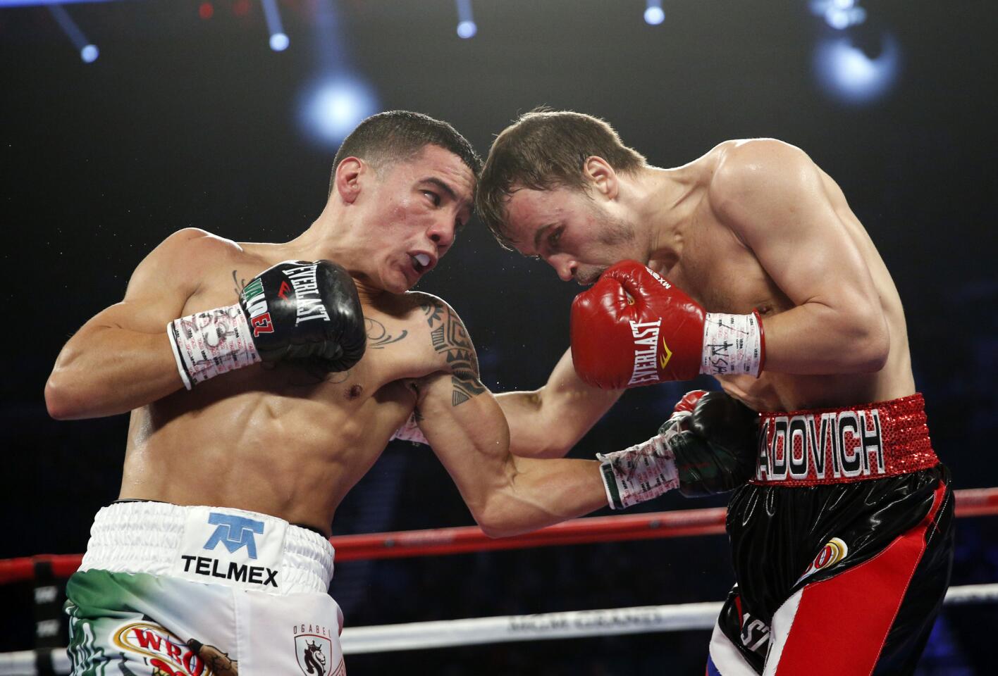 Oscar Valdez, left, of Mexico, punches Evgeny Gradovich, of Russia, during their featherweight title boxing bout Saturday, April 9, 2016, in Las Vegas. (AP Photo/John Locher)