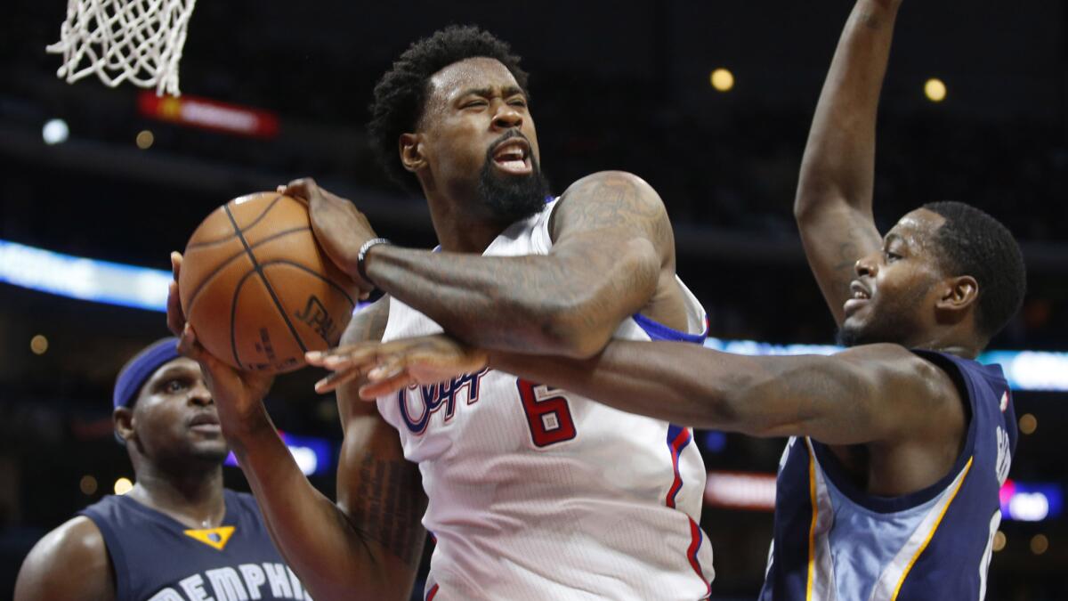 Clippers center DeAndre Jordan, left, grabs a rebound in front of Memphis Grizzlies forward JaMychal Green during a game at Staples Center on April 11.