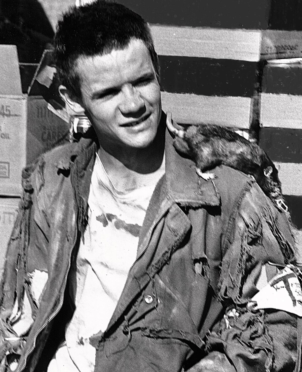 A young punk in tattered clothes with a rat on his shoulder