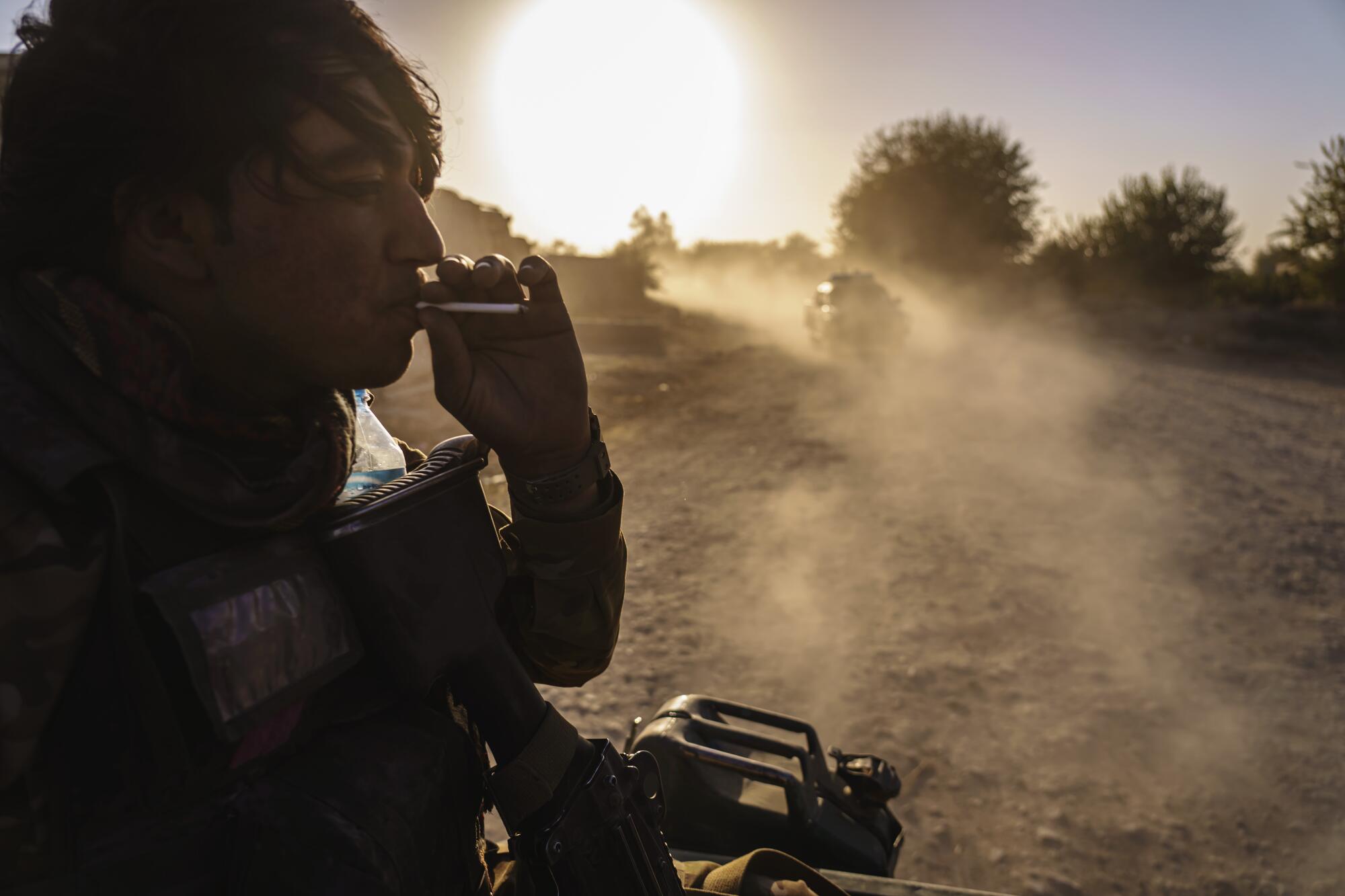  A man smokes in the back of a truck.