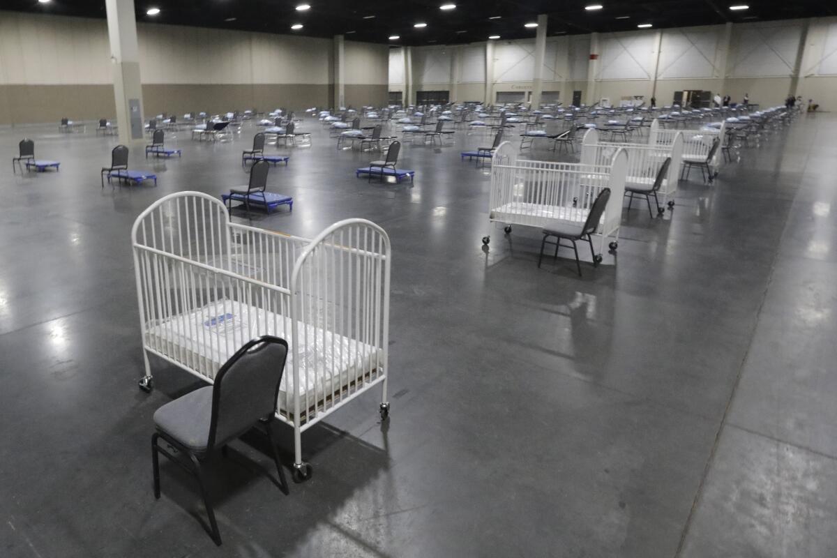 Cots and cribs are arranged in Sandy, Utah, at a care site set up amid the  pandemic. 