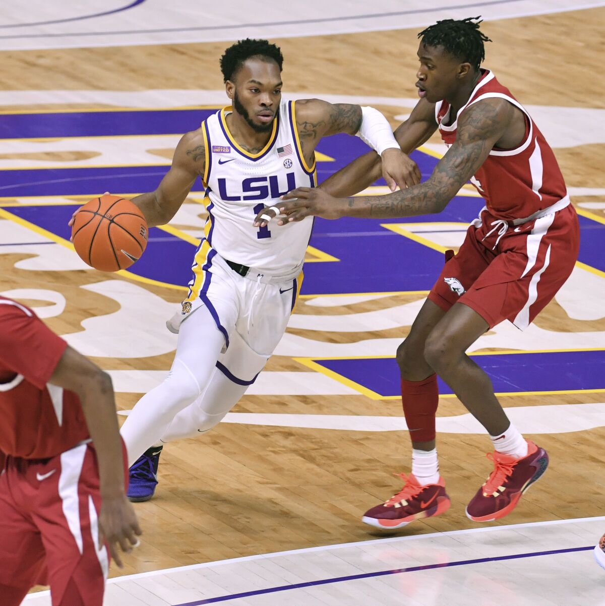 LSU guard Javonte Smart (1) drives past Arkansas guard Davonte Davis (4) during the first half of an NCAA college basketball game Wednesday, Jan. 13, 2021, in Baton Rouge, La. (Hilary Scheinuk/The Advocate via AP)