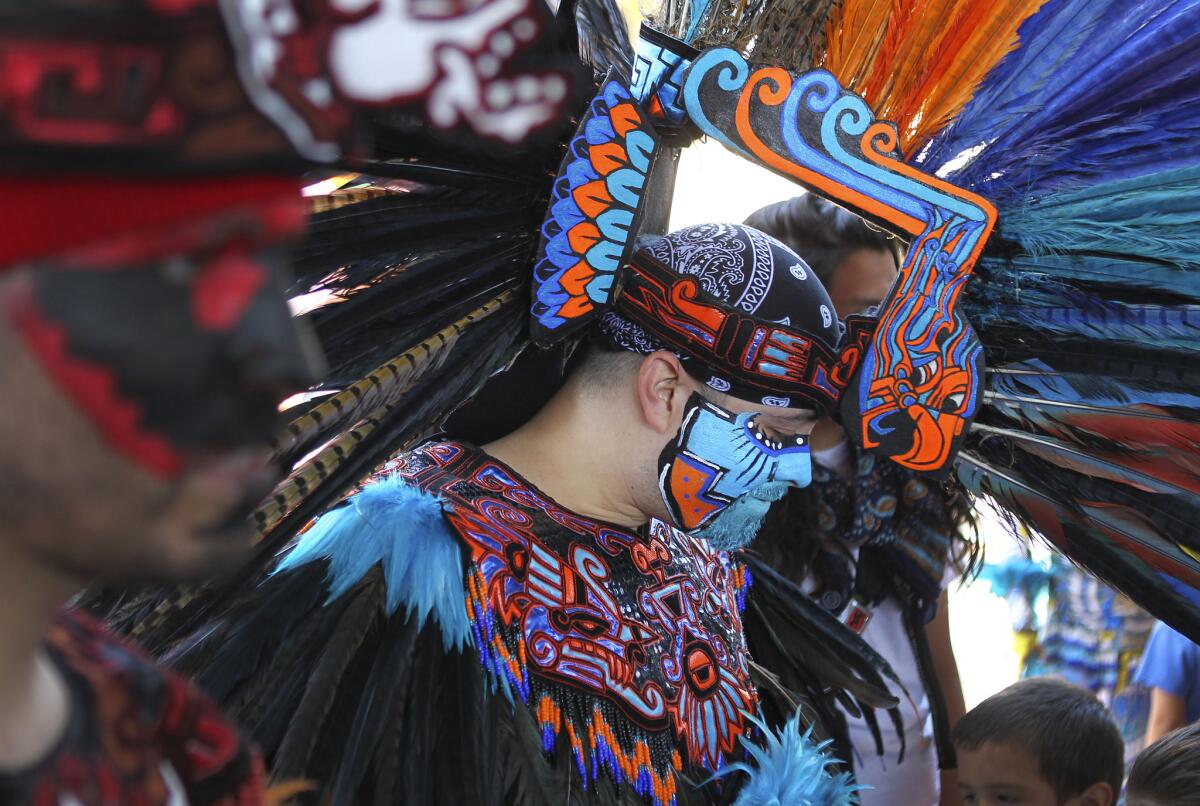 Chicano Park celebrated its historic designation with the 43 anniversary of the park in 2013. Juan Flores of the group Callpulli Mexica, dressed in Aztec apparel with facepaint and feathers adjusts his headdress during the celebration.